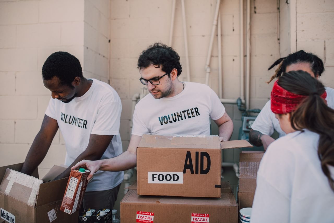 Free Group of volunteers packing food and aid boxes during a charity drive. Stock Photo